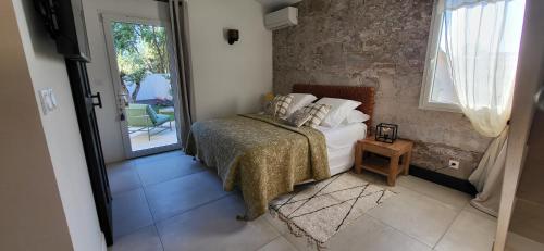 a bedroom with a bed and a door to a patio at La Cigale dans l'Olivier in Vernègues