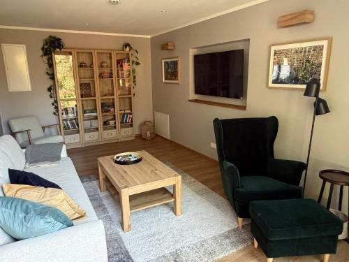 ein Wohnzimmer mit Sofa, Tisch und Stuhl in der Unterkunft Am Scheunengarten in Klausdorf Brandenburg