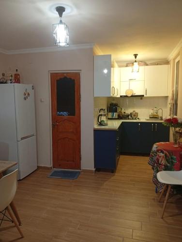 a kitchen with a white refrigerator and a red door at Nika's Home in Ureki