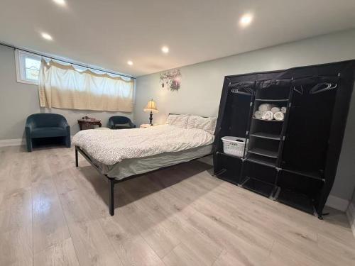 a bedroom with a bed and a black cabinet at Ideal Bachelor Suite For Couples in Aurora in Aurora