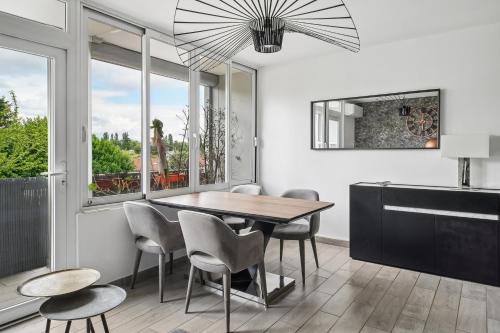 a dining room with a table and chairs and a window at Pop Eurexpo - Parking Privé, Terrasse, Climatisation in Bron
