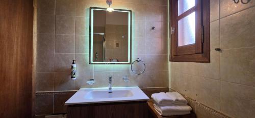 a bathroom with a sink and a mirror at Mouria Pension Rooms & Studios in Ancient Epidauros