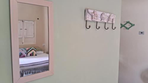 a mirror in front of a bedroom with a bed at Serrambi Praia Suites in Porto De Galinhas