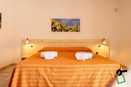 a bedroom with a large orange bed with two towels at Hotiday Gallipoli Sannicola in Gallipoli