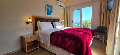 a hotel room with a bed and a window at Mouria Pension Rooms & Studios in Ancient Epidauros