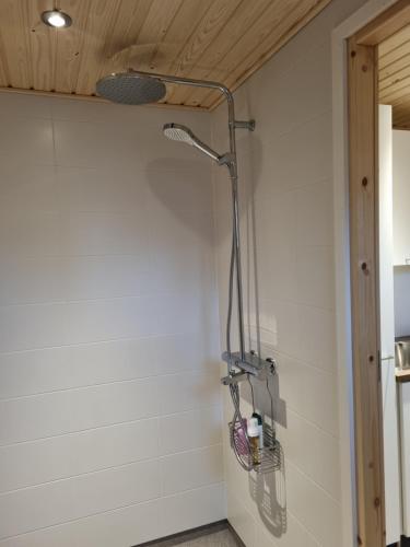 a shower in a bathroom with a white wall at Mattilan talo b&b in Impiö