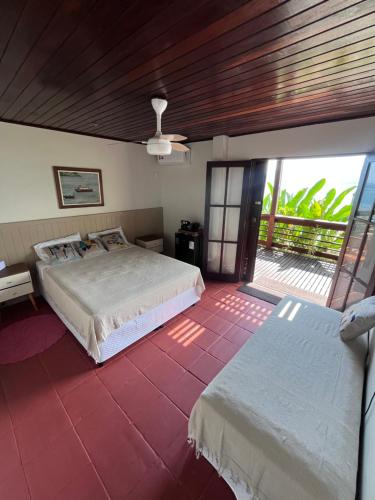 a bedroom with two beds and a balcony at Morada das marés in Angra dos Reis