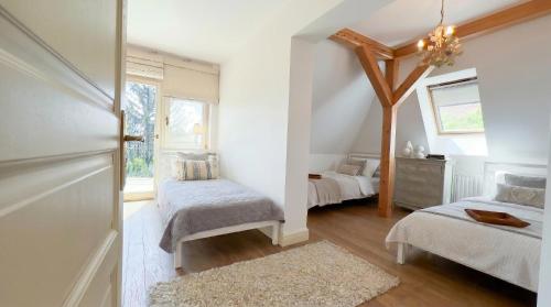 a bedroom with two beds and a window at Golden Villa Kraków - Stylowa Willa z Ogrodem i Grillem in Węgrzce