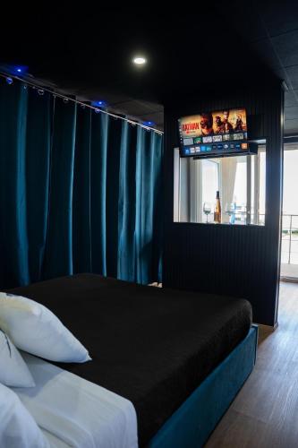 a bedroom with a bed and a flat screen tv at House Boat Cervia in Cervia