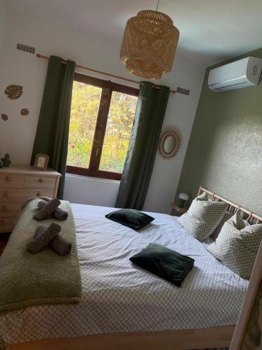 a bedroom with a bed with two teddy bears on it at Villa Rosette Ile du levant in Hyères