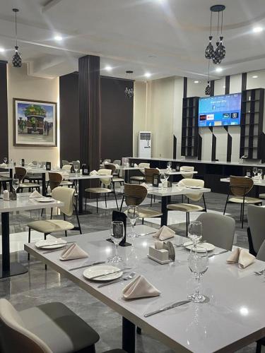 a restaurant with tables and chairs with glasses and napkins at Habor Hotel & Suites- Abuja in Abuja