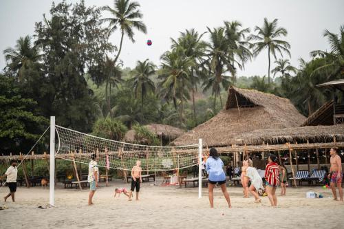 a group of people playing volleyball on the beach at Anahata Retreat Beach Front Resort in Mandrem