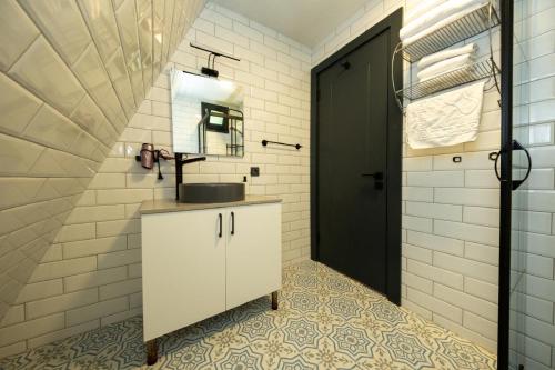 a bathroom with a sink and a black door at Begonvil Gümüşlük in Gümüşlük