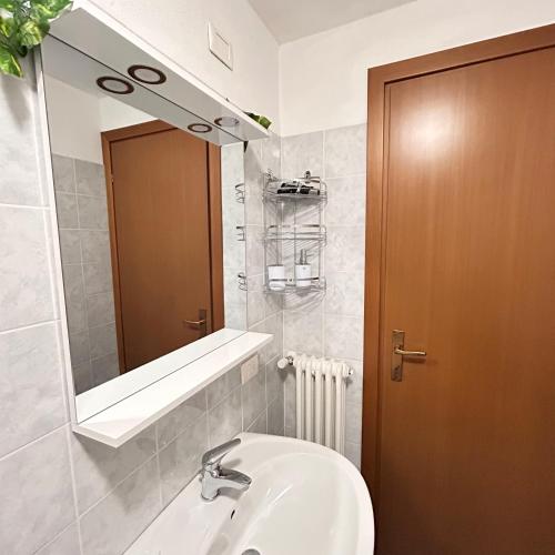 a bathroom with a sink and a mirror at Foresteria Kiki in Gravedona
