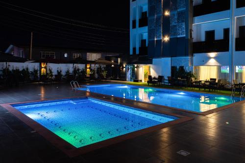 a swimming pool in a building at night at BON Hotel Kabuwol in Ibadan