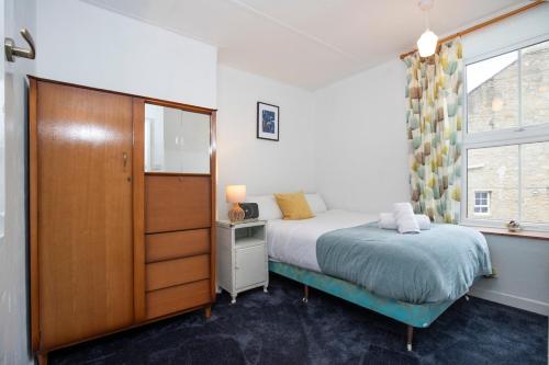 a bedroom with a bed and a dresser and a window at 2 Bedroom Cottage By Cozy Quarters Property Management Holiday Lets Wolsingham Near River Waskerley in Wolsingham
