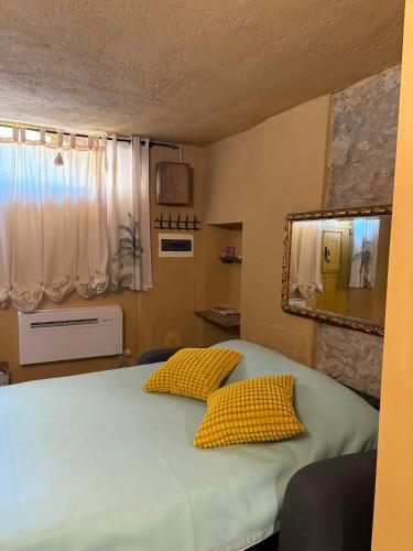 a bedroom with a bed with two yellow pillows at Le Soleil in Casale Marittimo