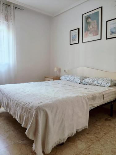 a bedroom with a large bed with a white bedspread at Paseo el Saladar in Denia