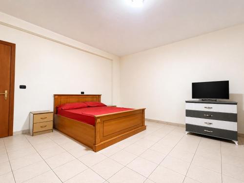 a bedroom with a bed and a flat screen tv at Hotel Garden Albania in Golem
