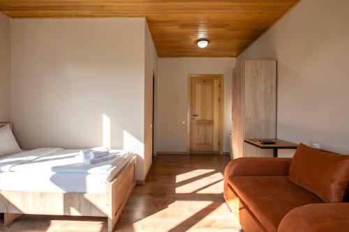a bedroom with a bed and a couch at Hotel Babuda in Mestia in Mestia