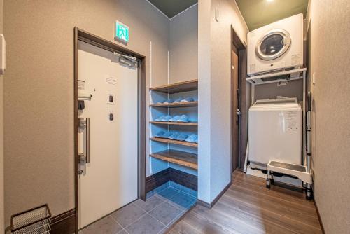 a walk in closet with a refrigerator in a room at メリエイト三崎通 in Kuwana