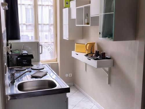 a small kitchen with a sink and a window at Studio chez Jef in Nuits-Saint-Georges