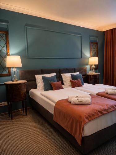 two beds in a hotel room with blue walls at Apartament Baron II ***** in Jelenia Góra