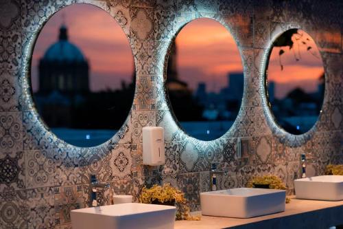 a bathroom with two sinks and two mirrors at Bogart 206 in Guadalajara