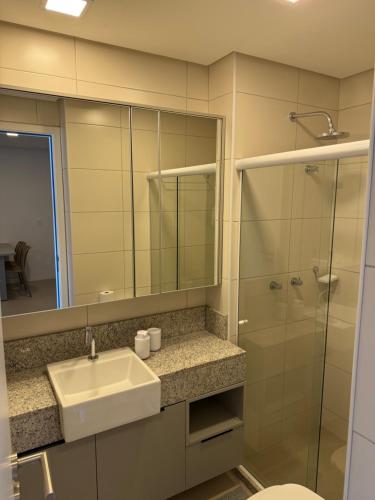 a bathroom with a sink and a glass shower at Flat Parque do Cais in Recife By Flatbpaiva in Recife