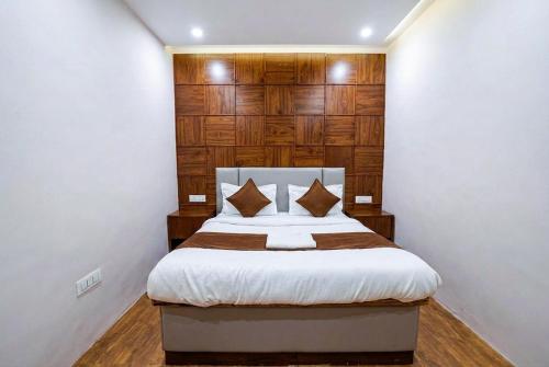 a bedroom with a bed with a wooden headboard at Hotel Velvet Dreams Inn & Banquet in Kharar