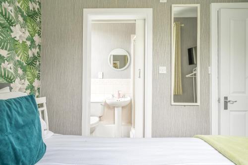 a bedroom with a bathroom with a sink and a mirror at The Capsule Room at The Lairbeck in Keswick in Keswick