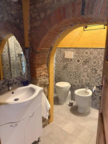 a bathroom with two sinks and a toilet at Le Soleil in Casale Marittimo