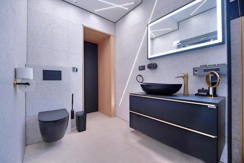 a bathroom with a black sink and a toilet at Timm - Luxury Villas in Vodice
