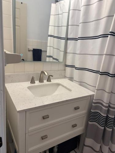 a bathroom with a sink and a shower curtain at 8 minutes from 2026 FIFA World Cup Final! in Rutherford