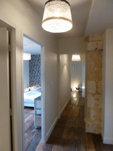 - un couloir avec une chambre dotée d'un lit et d'un lustre dans l'établissement Le Grand Appartement d'Albusse, à Sarlat-la-Canéda