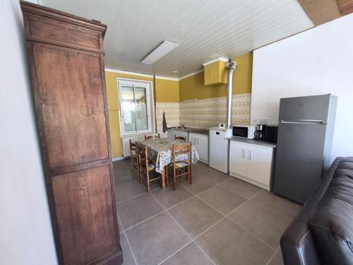 a kitchen with a table and a refrigerator at Chez Mamie in Donchery