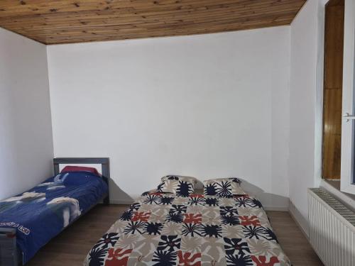 a bedroom with a bed with a quilt on it at Chez Mamie in Donchery