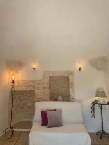 a living room with a white couch and two lamps at Trullo Nunuccio in Ceglie Messapica