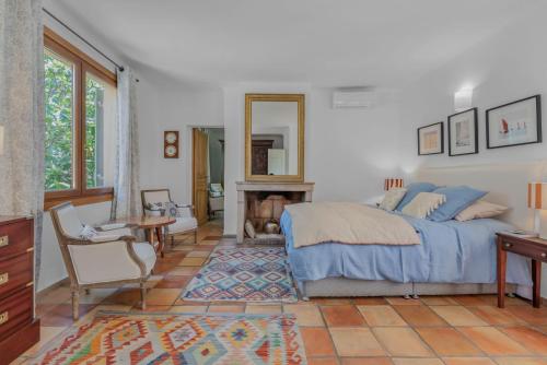 a bedroom with a bed and a desk and a mirror at Maison Magdeleine in Saint-Tropez