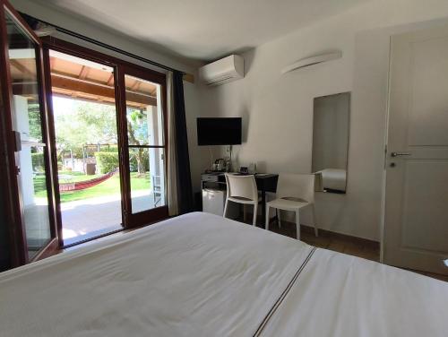 a bedroom with a bed and a table with chairs at Hotel La Posta di Torrenova in Orbetello