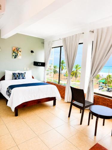 a bedroom with a bed and a view of the ocean at Paradise Jaco Beach Front in Jacó
