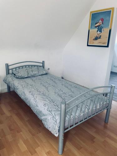 a metal bed in a room with a picture on the wall at GEM Stay in Oberhausen