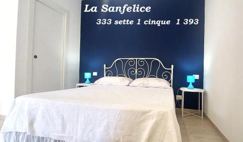 a bedroom with a white bed with a sign on the wall at La Sanfelice in Agropoli
