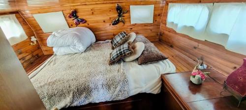 a bedroom with a bed in a room with wooden walls at Bateau SKAMP in Mâcon