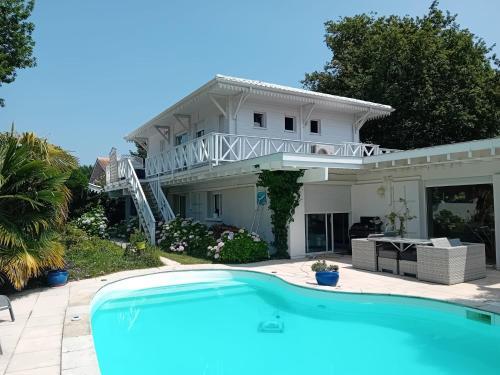 a house with a swimming pool in front of it at La Nomade in Andernos-les-Bains