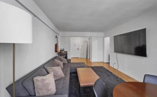 a living room with a couch and a table at Lavish Columbus Circle Manhattan Apartment by Central Park & Times Square ADULTS ONLY in New York