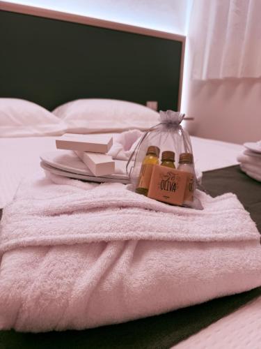 a bed with a white towel and two bottles of oil at Casa Cloe in LʼAquila