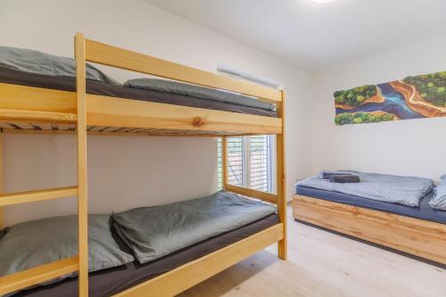 two bunk beds in a room with a window at Apartmán U mlýnu in Červená Voda