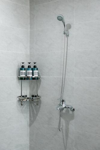 a shower with three bottles on a shelf in a bathroom at Long Hotel in Danang
