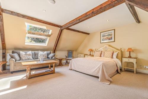 a bedroom with a bed and a couch at The Coachmans Loft in Bix